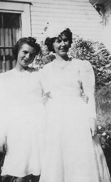Eileen (O'Toole) Hennessy and Lucy (Hennessy) Jarratt on Lucy's wedding day, August 26, 1942, in front of the old Hennessy Homestead, Bathurst, NB.